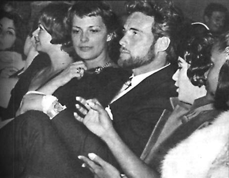Women are distracting Steve Reeves from watching himself on screen.